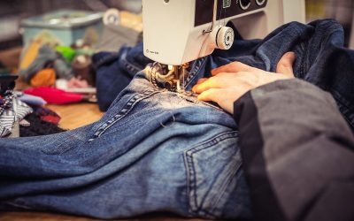 Close up of somebody repairing some denim jeans on a sewing machine at The Remakery.
